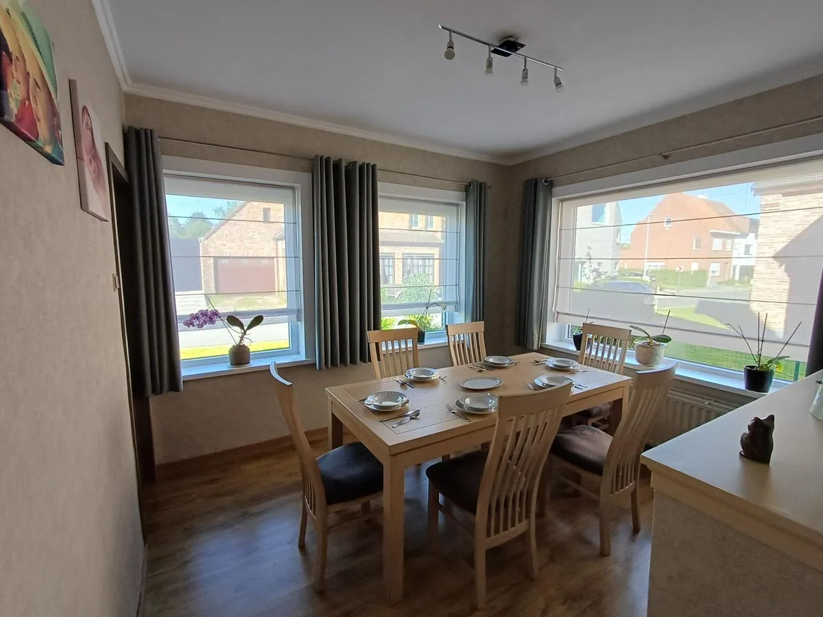 Eetkamer met grote ramen en houten tafel