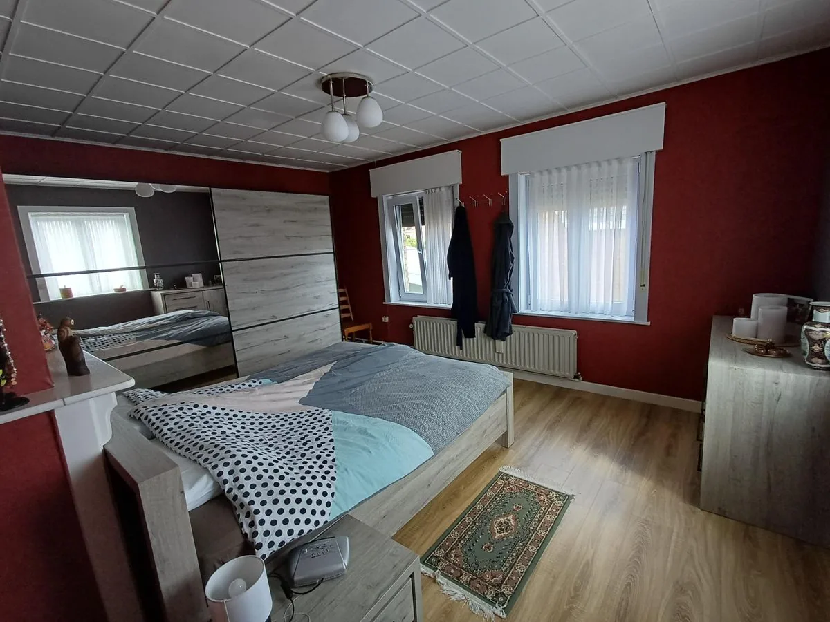 Ruime slaapkamer met tweepersoonsbed en spiegelkast